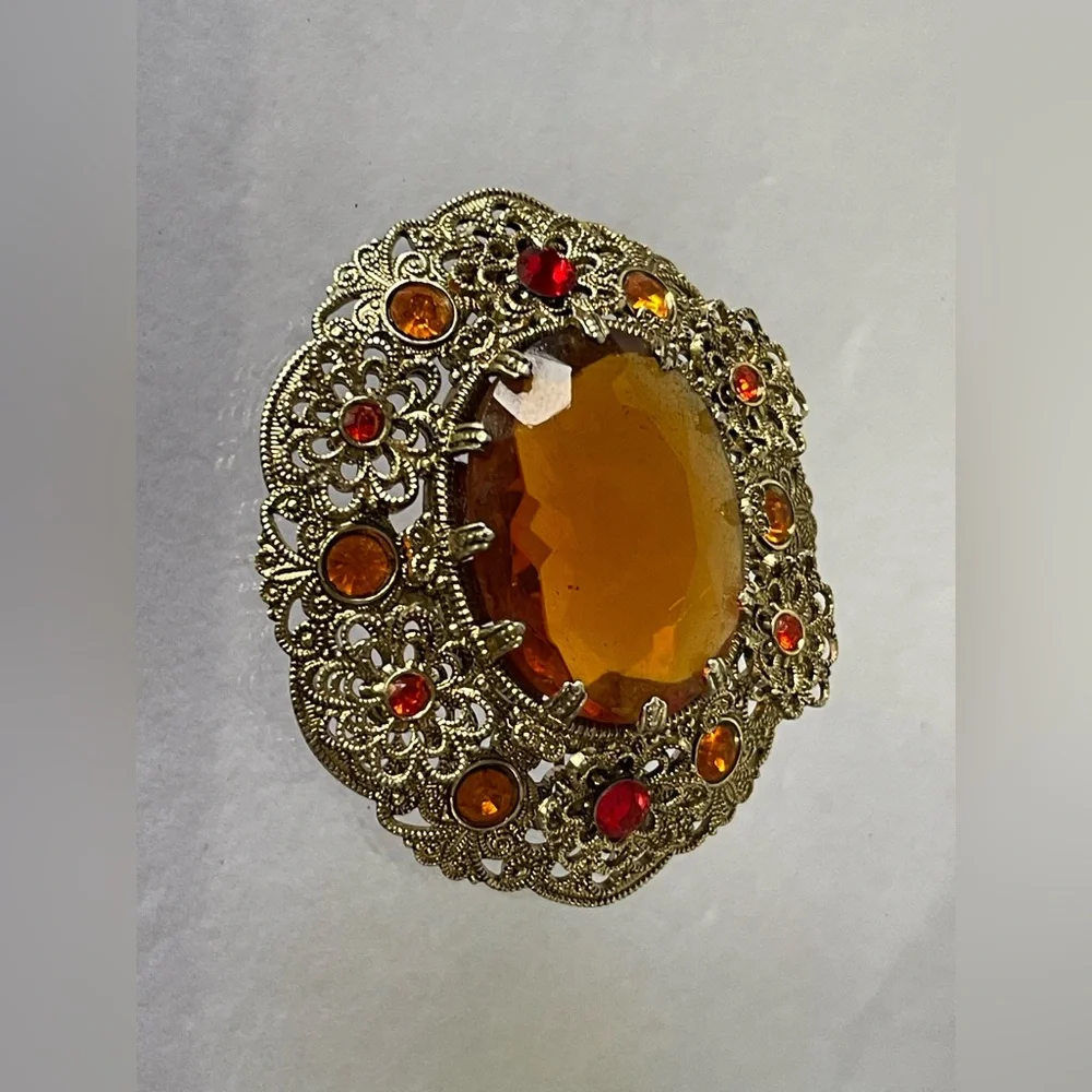 Vintage West Germany brooch featuring a large amber topaz glass filigree gold